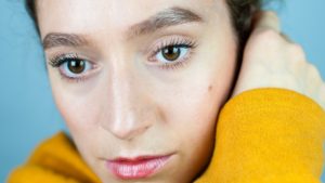 Up close portrait of a woman in a yellow top